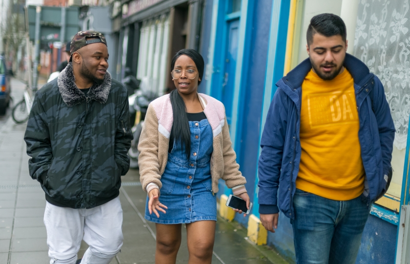 Three teenagers walking together on a street